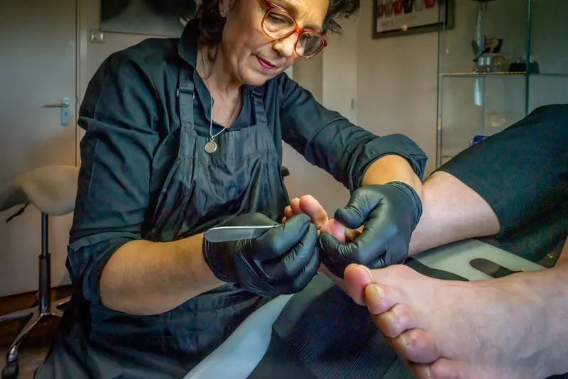 Sherryl vijlt de teennagels van een klant