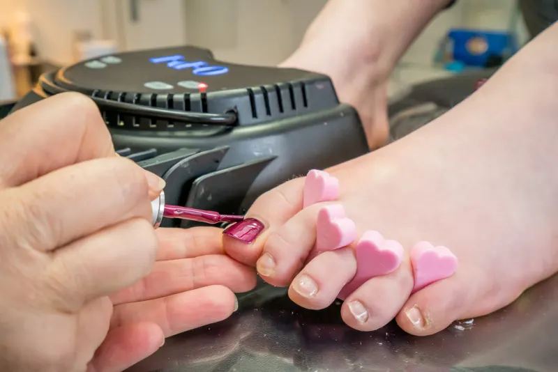 Teennagels lakken in roze, met teenspreiders